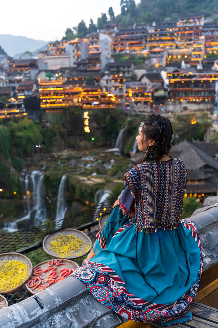 Calles empedradas y canales antiguos con puentes de piedra en la ciudad vieja de Lijiang, promoviendo el turismo auténtico en China.